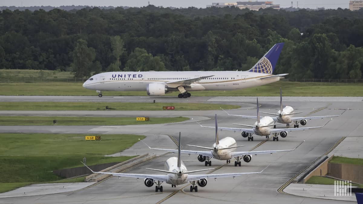 United Airlines jets line up along taxiway to take off at Houston airport. United is increasing its international schedule.