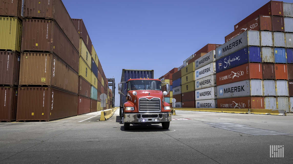 Red drayage truck loading container at port