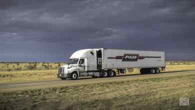 P.A.M. Transportation truck on highway under dark clouds