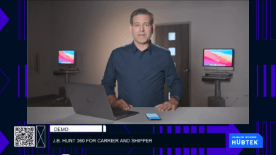 Man standing behind computer and phone talking