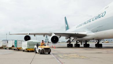 A cargo tug drops off a load next to a Cathay Pacific jet. The air cargo business in June was down a fifth from last year's level.