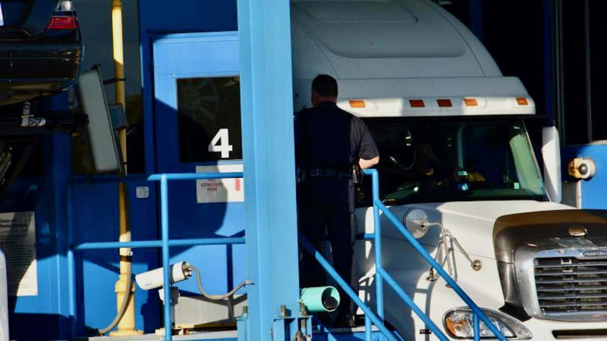 A U.S. Customs and Border Protection Officer talks with a truck driver at the Peace Bridge border crossing in Buffalo, New York. Customs and Border Protection Officers found $20 million of marijuana during an inspection of a trailer in June.