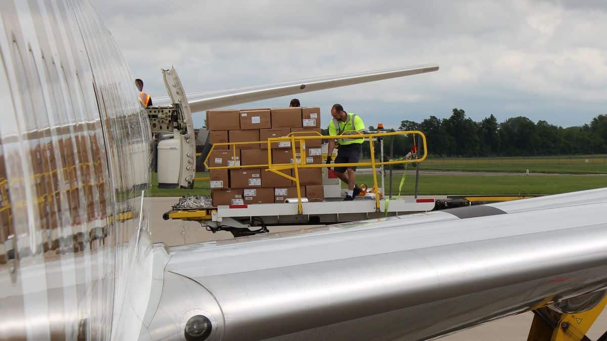 Pallets of freight offloaded an Emirates 777 passenger plane onto a hydraulic lift. The use of passenger planes as freighters is dictated by strong market economics.