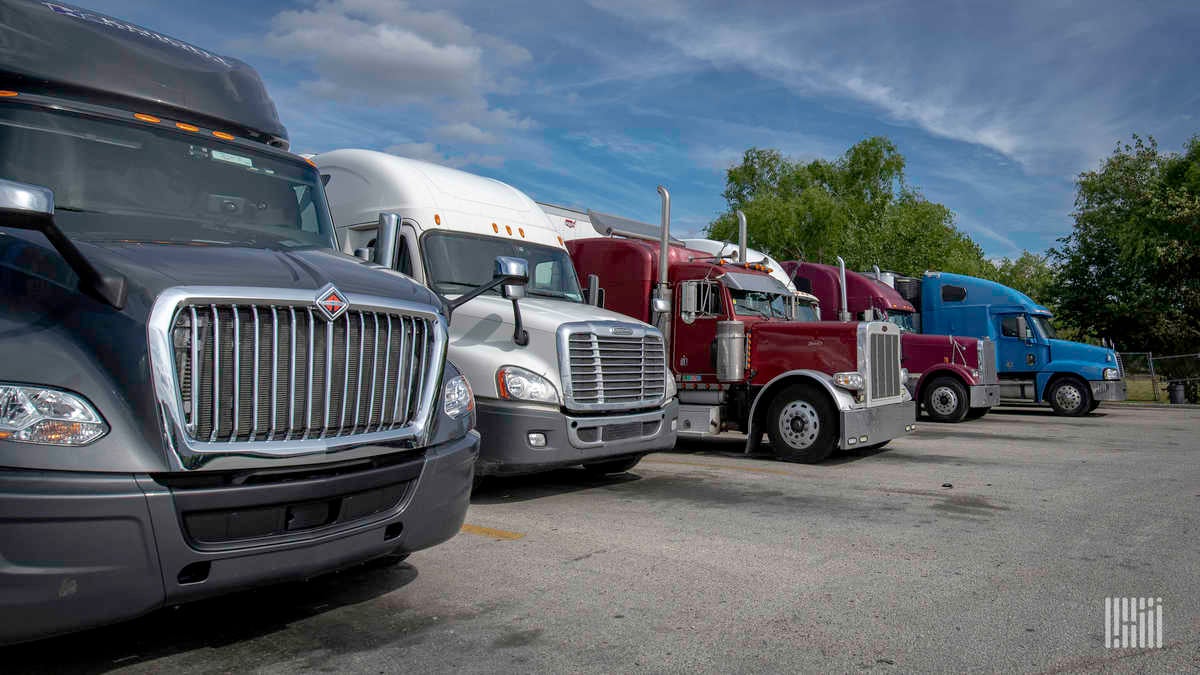 Different makes/models of Class 8 trucks in a parking lot. 