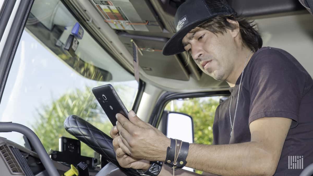 A driver checks a message about his next pick up on his smartphone.