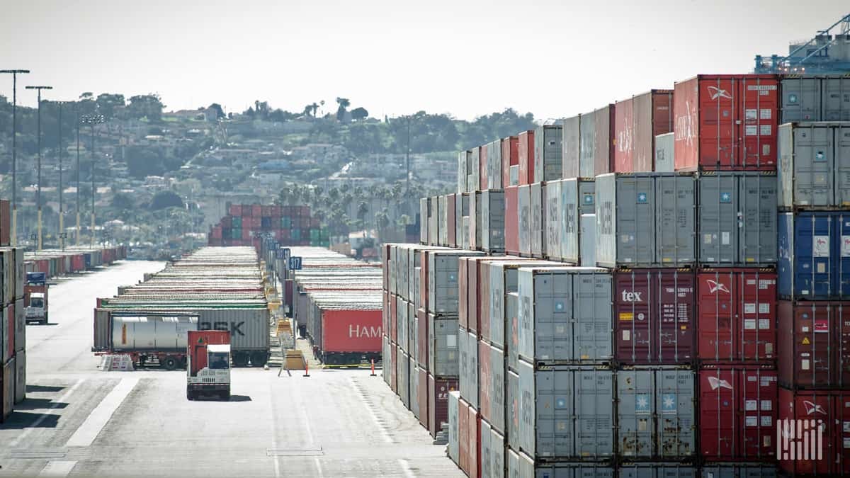 In this photo, the stacks of containers look almost as high as the hills behind them.