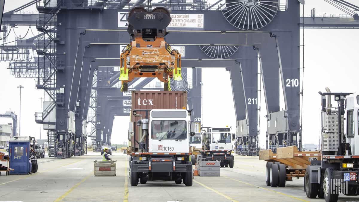 One of this port's cranes about to take a container from a drayage tractor.