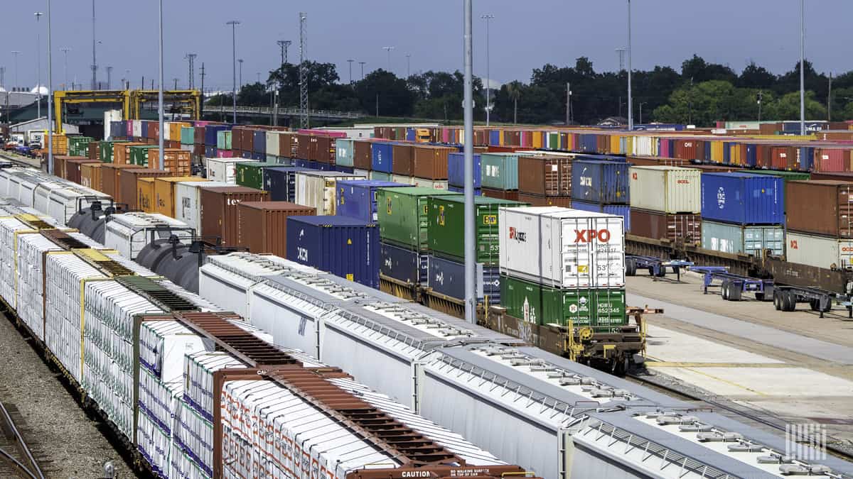 A photograph of parked intermodal containers and trains at a rail yard.