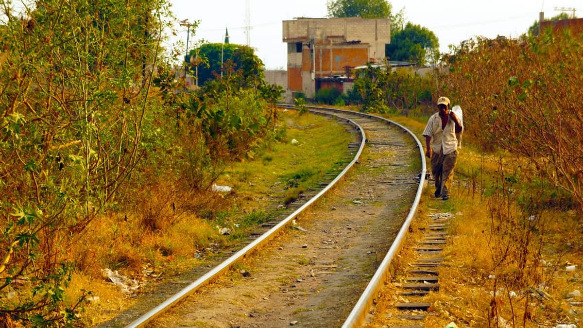 A man walks along railroad tracks in Mexico.