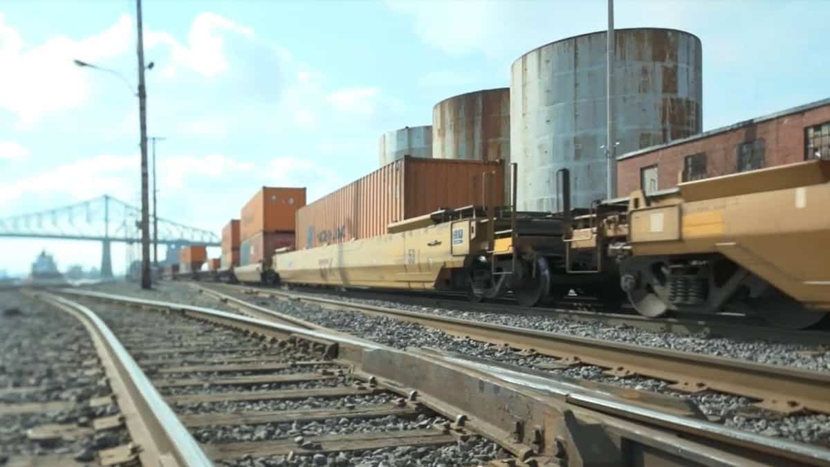 A photograph of a train with hauling intermodal containers at a rail yard.