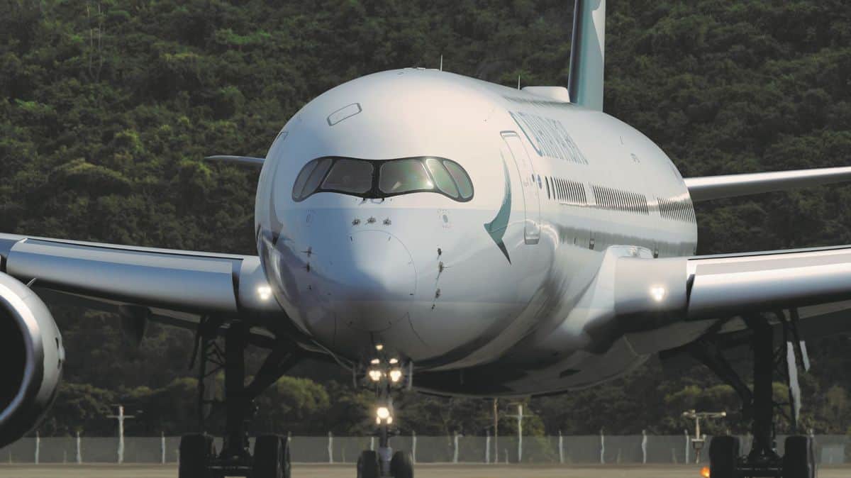 Staring straight ahead at a big white jet. from the front. Cathay Pacific is storing planes in sunny climates.
