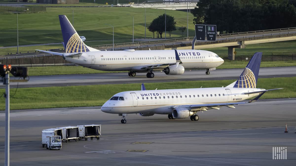 White jets with blue tails pass each other at Houston's main airport.