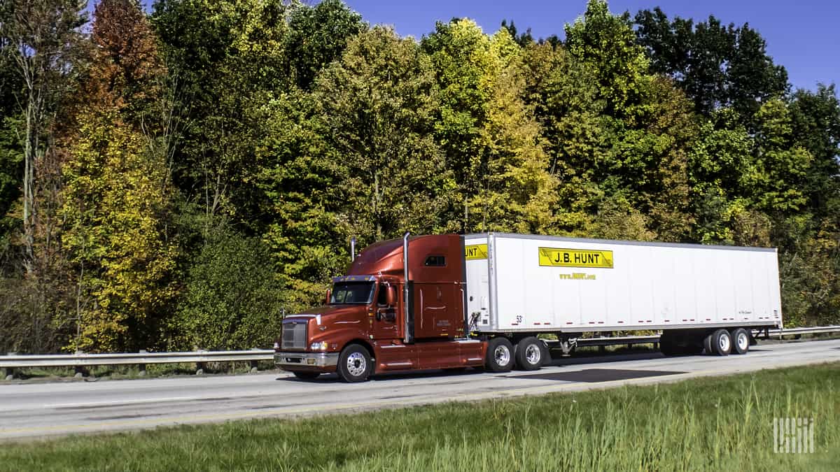 Red J.B. Hunt truck against autumnal forest