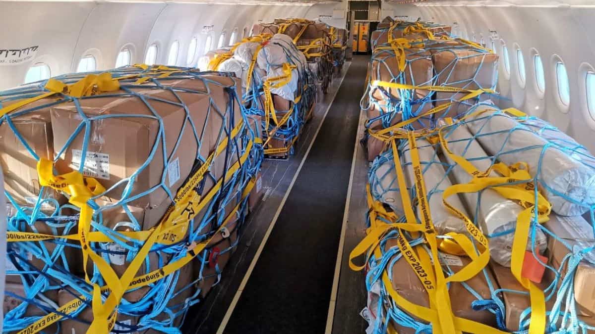 Boxes tied down in the passenger cabin with netting after seats removed. from Scoot jet.