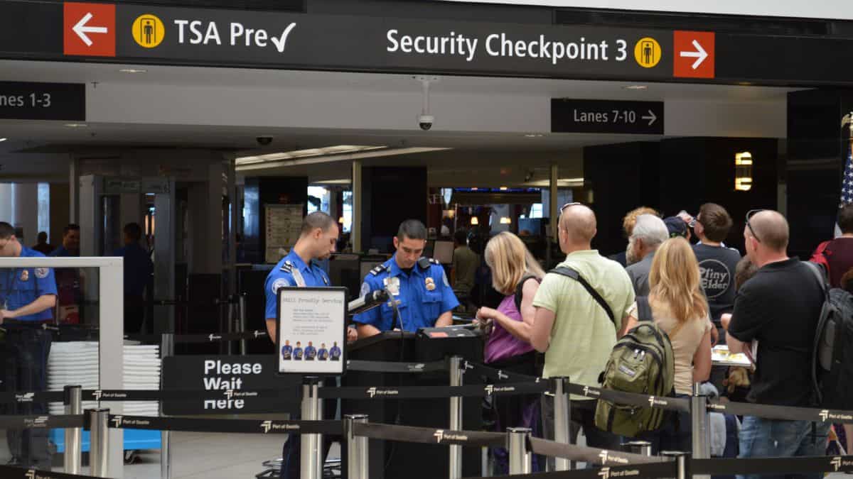 Travelers in line at a TSA airport checkpoint.