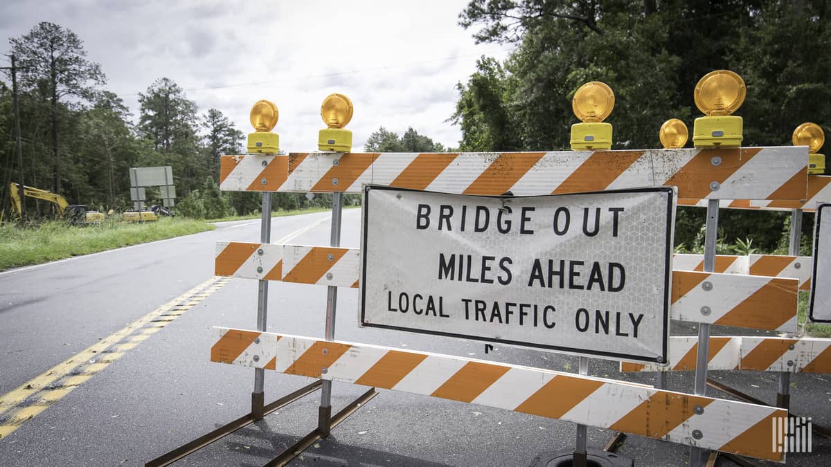 Road closed sign near a bridge.