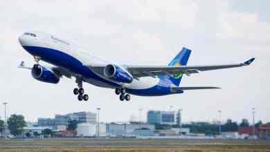 A white Airbus A330 with a blue tail takes off.