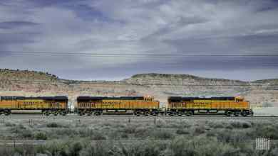 A photograph of a BNSF train traveling along a desert-like mountain pass.