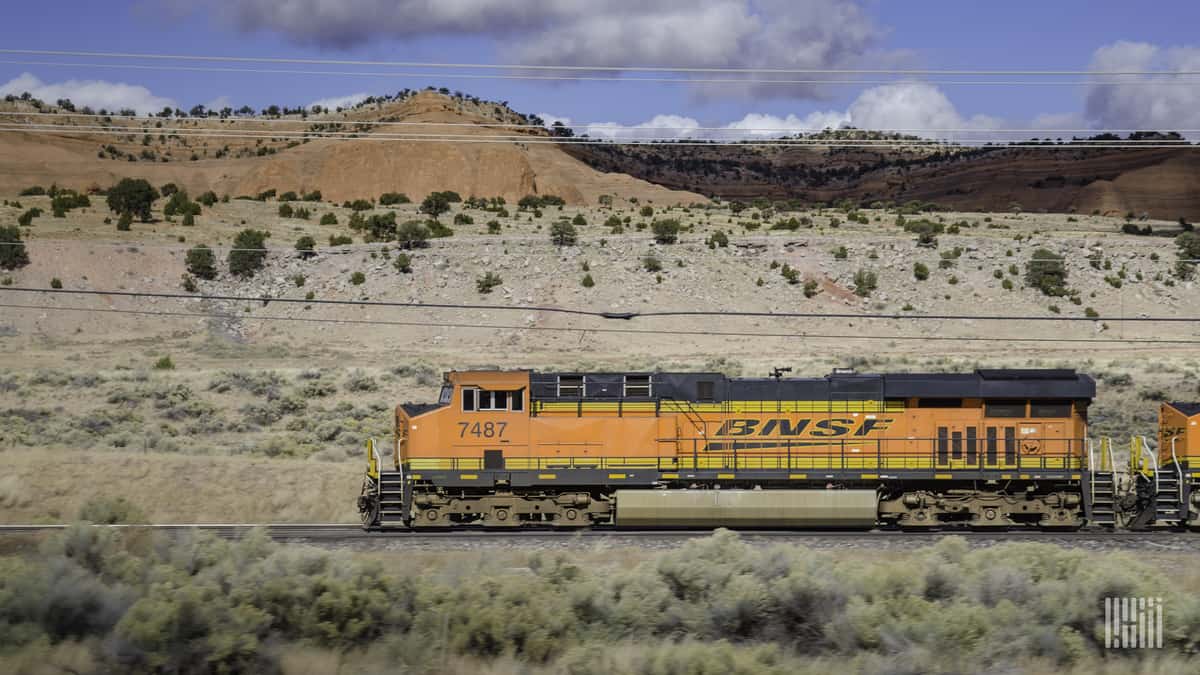 A photograph of a BNSF train traveling through a desert landscape.