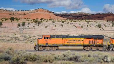 A photograph of a BNSF train traveling through a desert landscape.