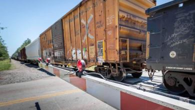 A photograph of a train at a highway grade crossing.