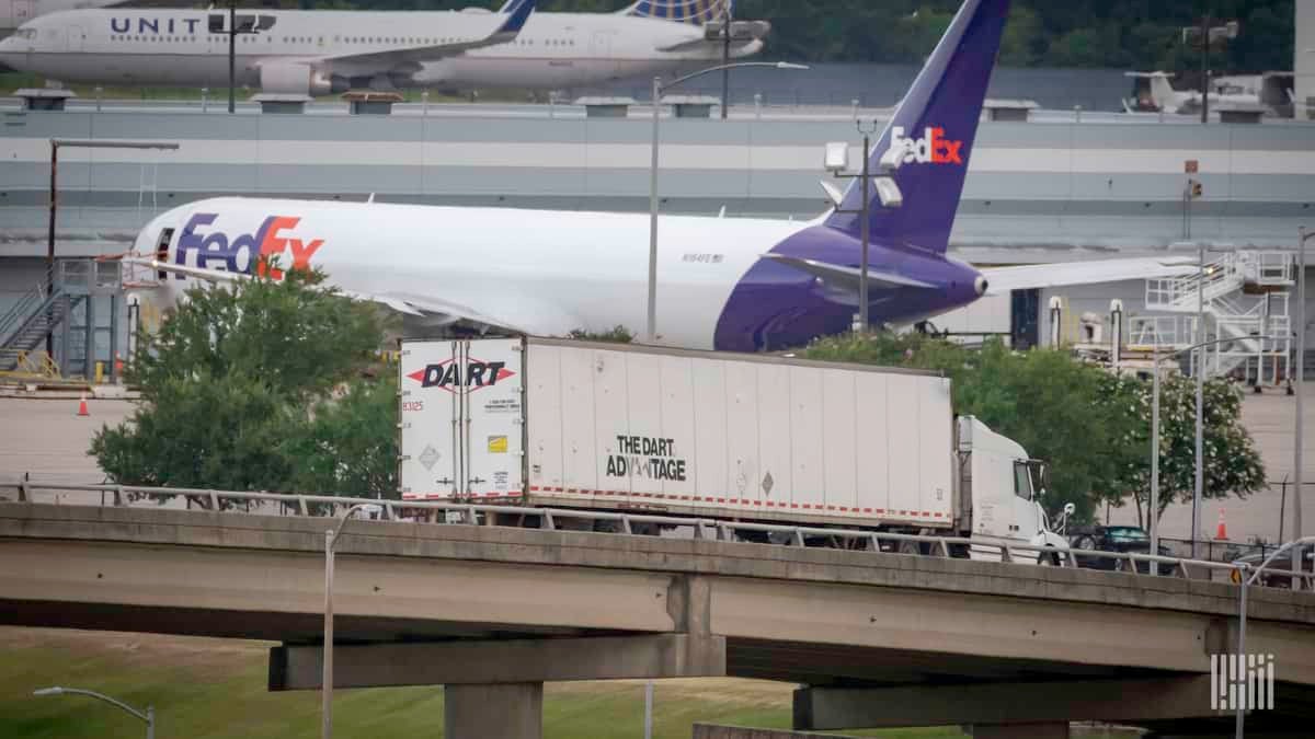 A white and purple FedEx plane on the airport apron.