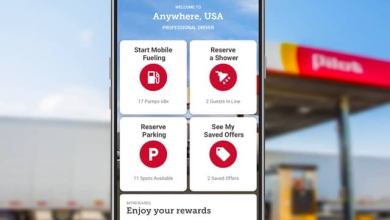 Close-up of phone with driver app in front of Pilot gas station
