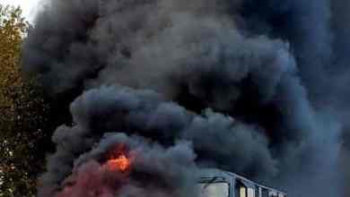 Truck on fire after train slams into it.
