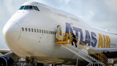 A white Atlas Air jumbo jet, with man walking up stairs into side door.