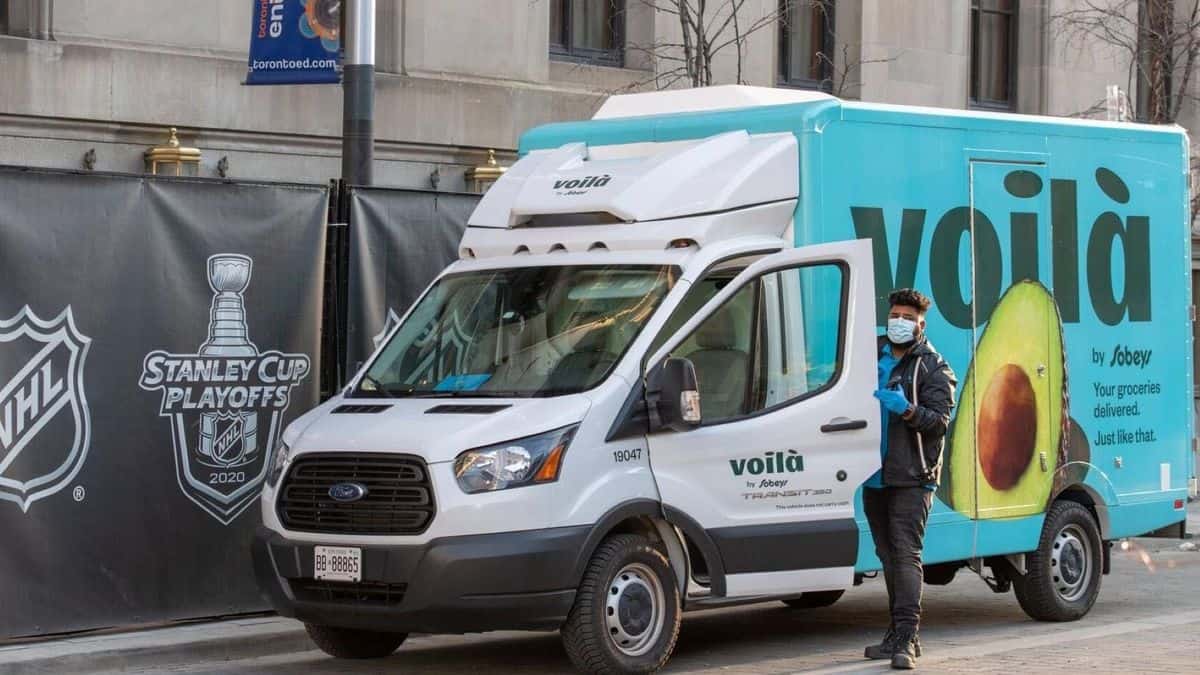 A white grocery delivery van parked on the street.