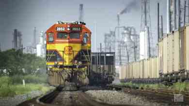 A Kansas City Southern train travels past a city.