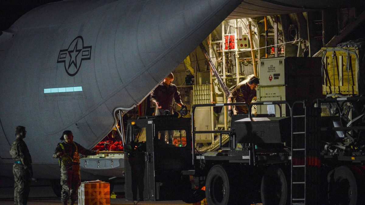 U.S. military personnel unloading equipment from back of a