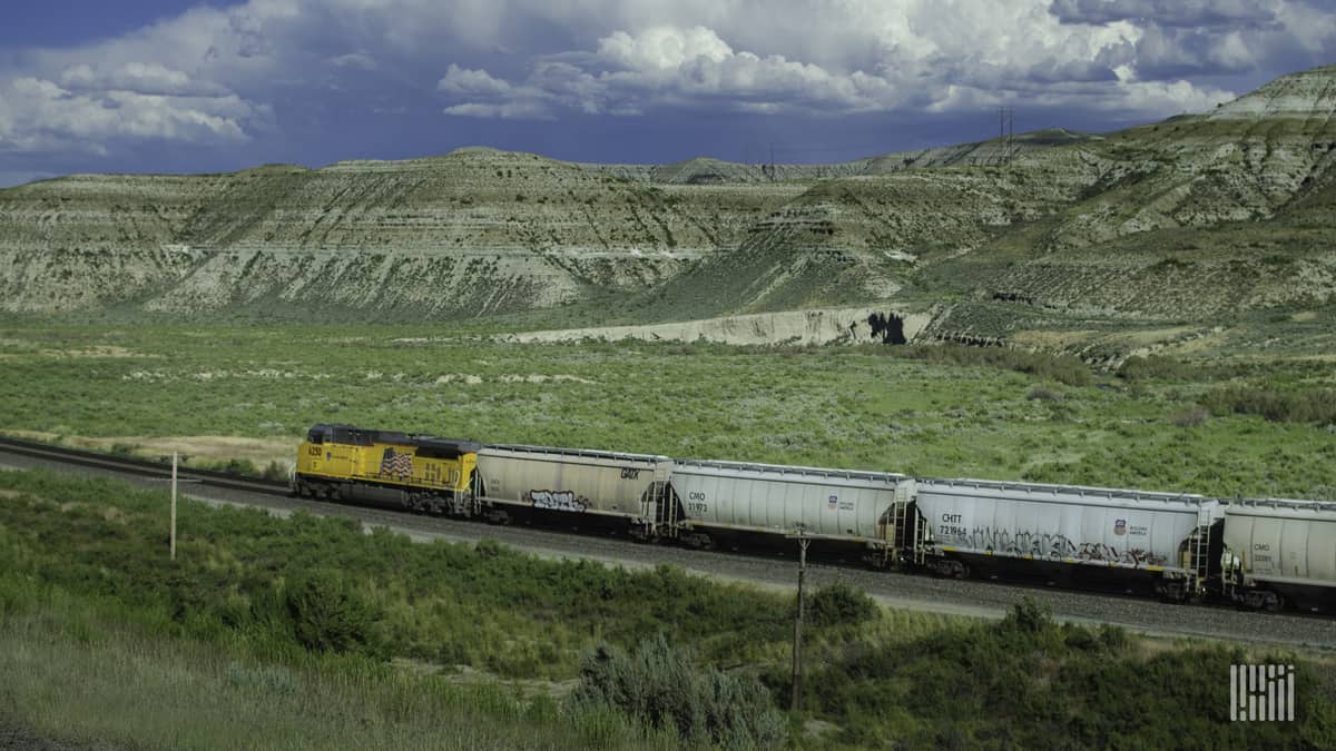 A photograph of a Union Pacific train traveling through a grassy field.