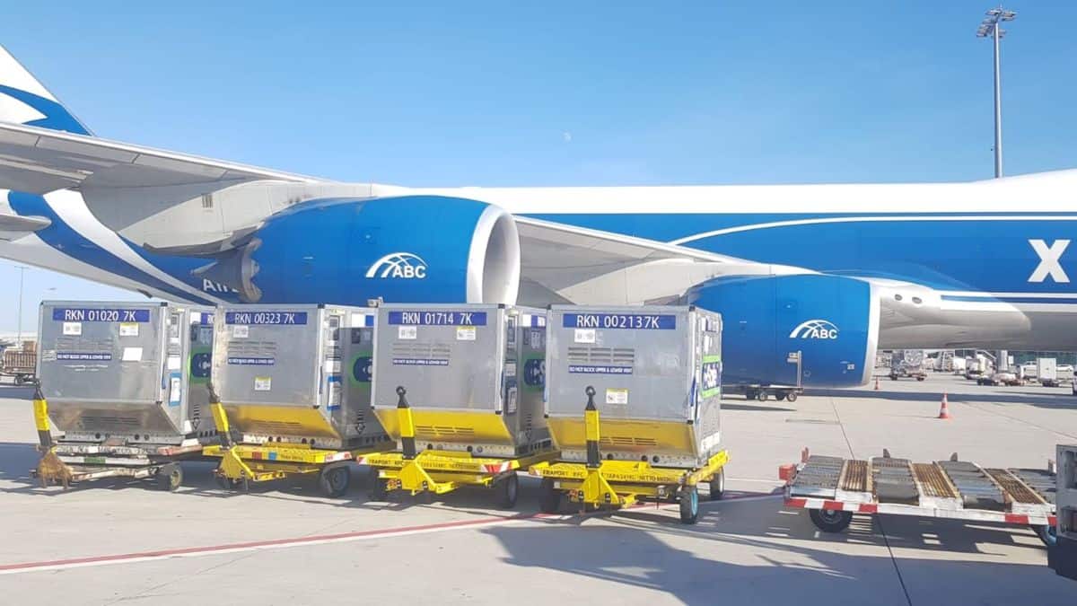 A big blue cargo jet with a white top gets ready to receive temperature-controlled containes.