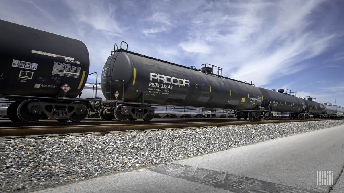 A photograph of three tank cars parked in a rail yard.