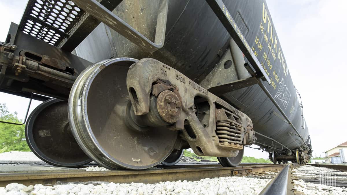 A close-up photograph of a train wheel sitting on rail track.