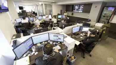 Brokers inside office sitting in front of computer screens