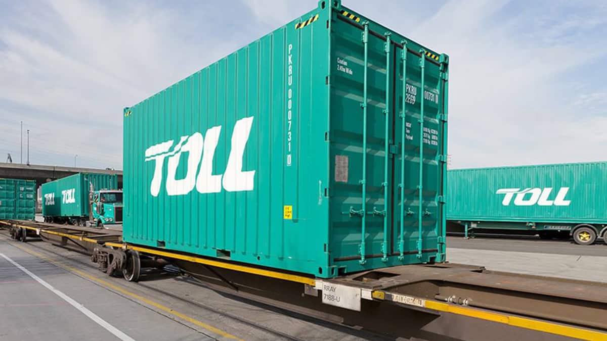 A green Toll Group container sitting on a rack.