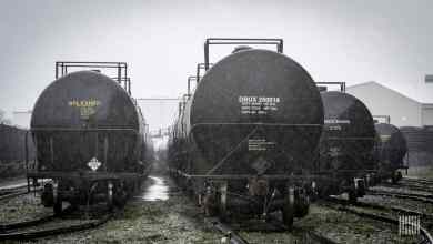 A photograph of tank cars parked in a rail yard.