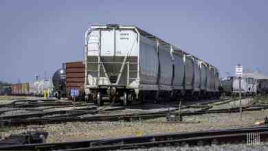 A photograph of a hopper car parked in a rail yard.