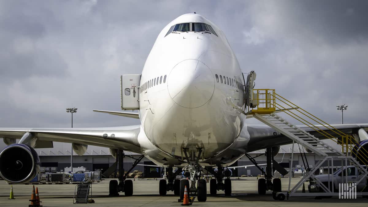 Front-end of a Boeing 747 cargo jet, looking straight on to its nose. The plane is white.
