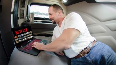 Truck driver in his sleeper selecting a streaming movie to watch.