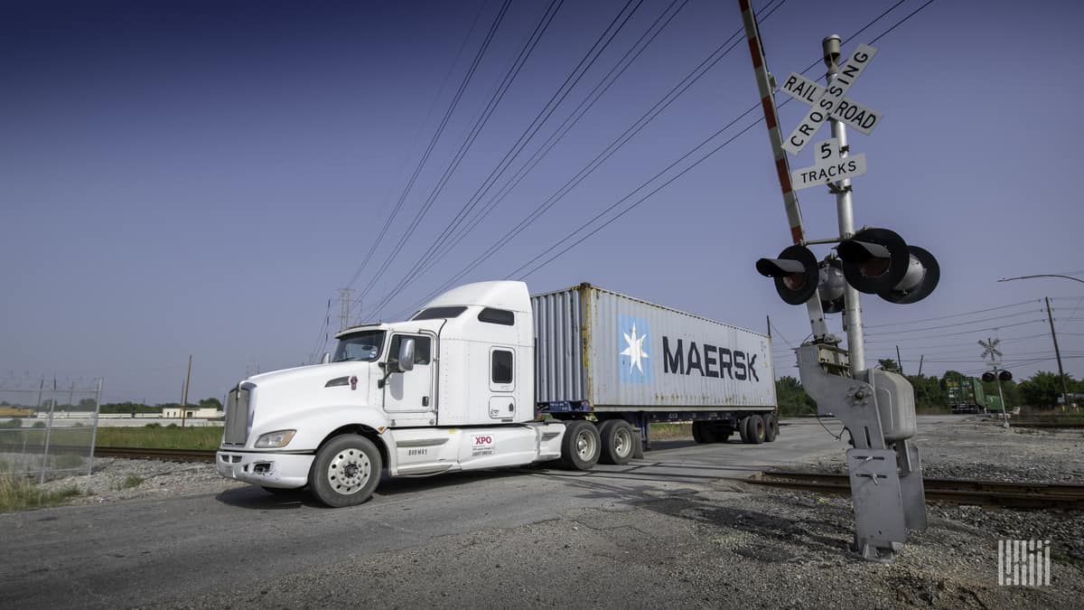 A photograph of a truck passing through a highway rail grade crossing.