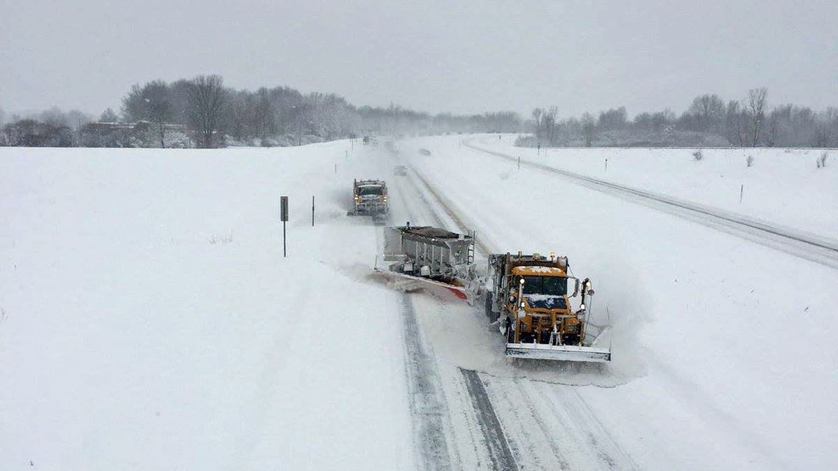 Plows clearing heavy snow from a New York highway.