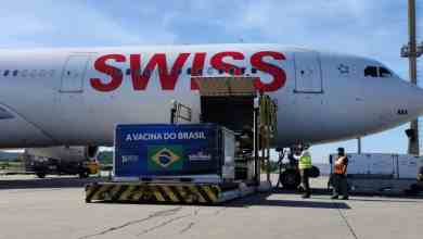 SWISS plane loaded with cargo on sunny day.