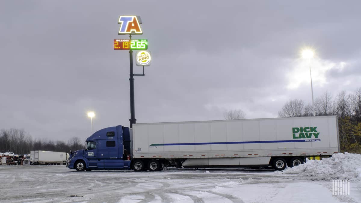 Driver entering truck stop on a snowy day.