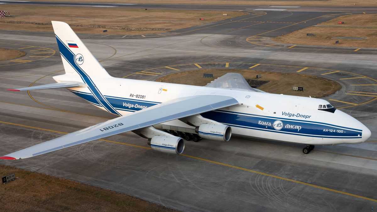 A large, white super freighter on the ground, with camera view from above.