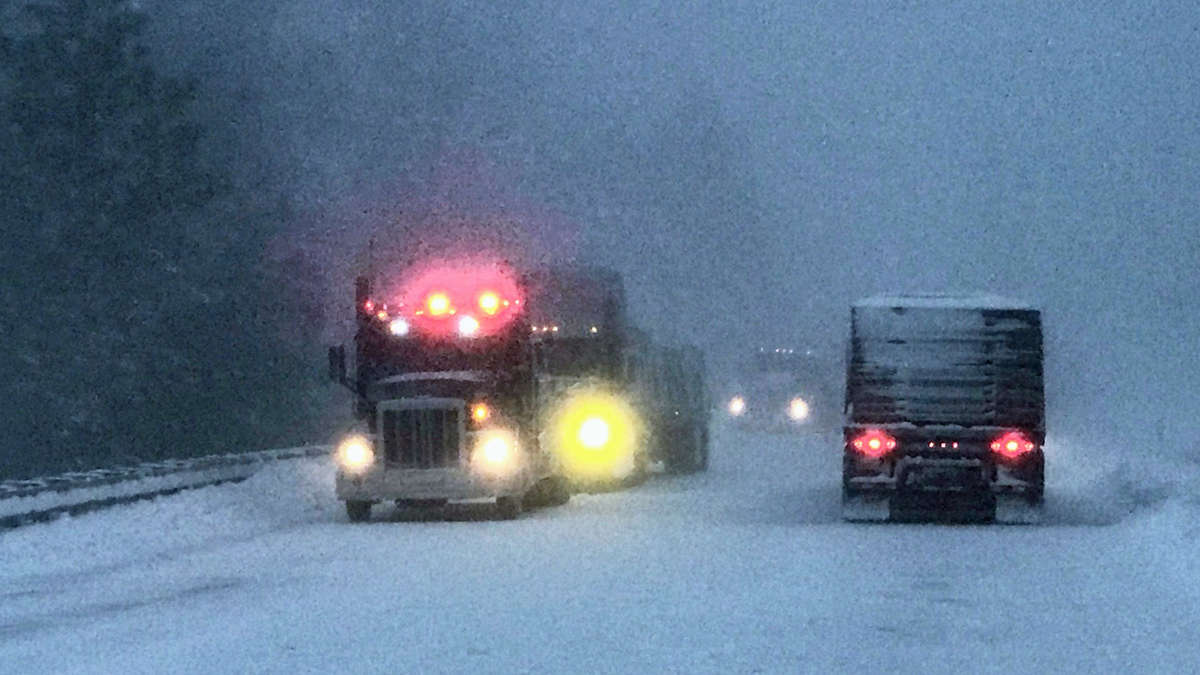 Tractor-trailers heading down snowy Washington highway.