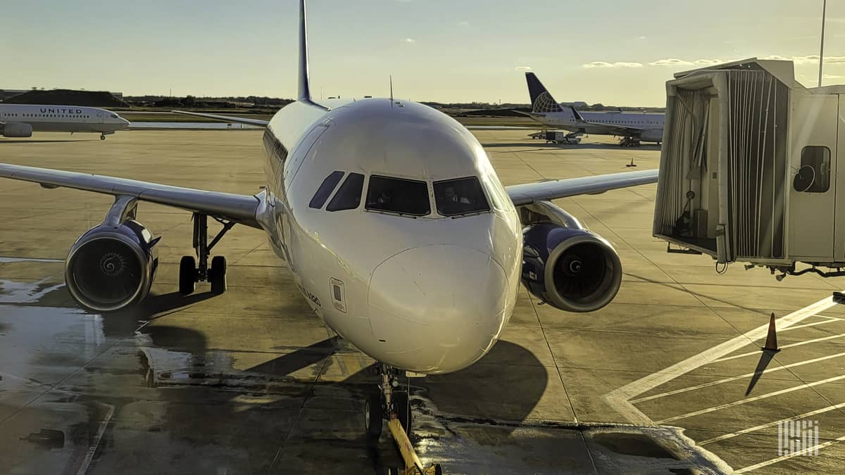 Straight ahead view of plane at airport gate on a sunny morning.