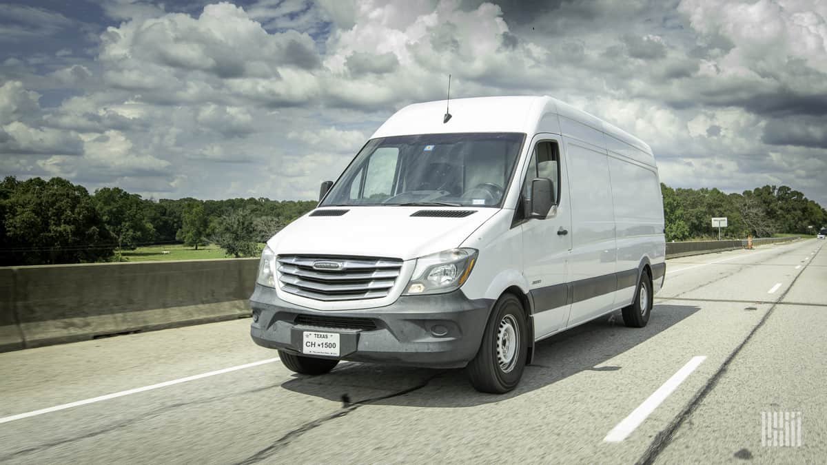 A photograph of a van driving on a road.